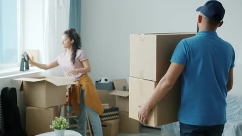 Man Carries Boxes into Brightly Lit Living Room