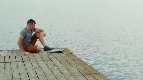 Man on the pier working on a laptop