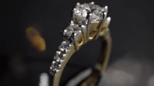 Gros plan extrêmement détaillé de la bague en diamant lors de la rotation sur fond sombre