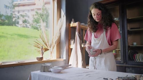 Woman Shaping Clay Bowl in Bright Studio