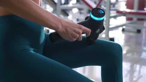 Girl Massages Hip in Gym Close Up