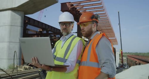 Engineers Reviewing Laptop on Construction Site