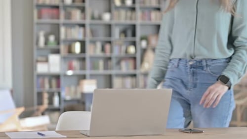 Joven profesional que regresa y se sienta y trabaja en la computadora portátil