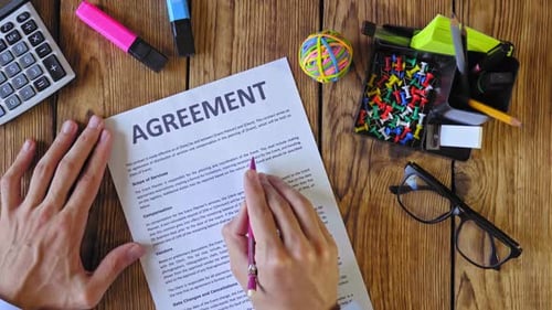 Reviewing agreement with pen on wooden desk