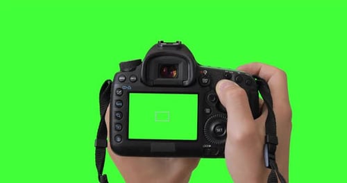 Professional photographer or filmmaker adjusts the DSLR camera settings before shooting.