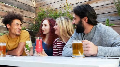 Friends Laughing and Talking with Drinks Outdoors