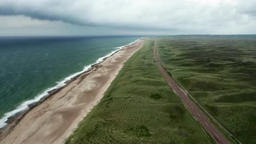 Drone Flight Rising Over Grass Landscape And Road Next To Beach