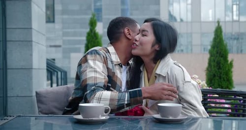 Man Gives Gift to Woman at Outdoor Cafe