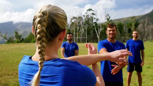 Female trainer training people in boot camp 4k