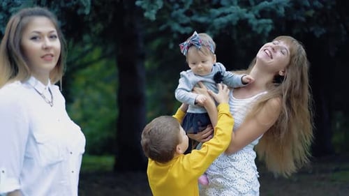 Mother Holds Infant As Young Boy Hugs Her