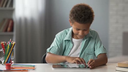 Little Clever Kid Swiping Tablet Playing in Interactive Educational Application