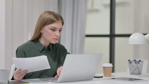 Young Woman Working on Laptop in Modern Office