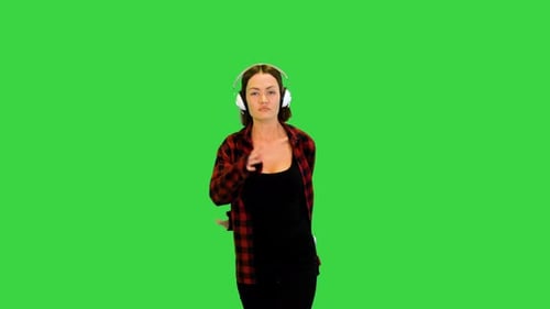 Young Girl with Headphones Dancing and Laughing on a Green Screen Chroma Key