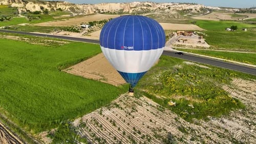 Hot air balloons fly over the mountainous landscape of Cappadocia, Turkey.