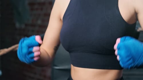 Woman With Boxing Tape Bouncing Fists in Gym