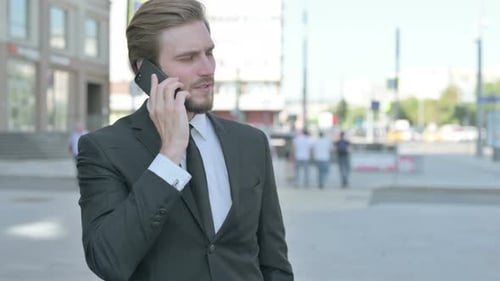 Young Adult Man Talking on the Phone Outdoors