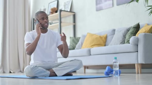 Man Talking on Phone While Sitting Cross Legged
