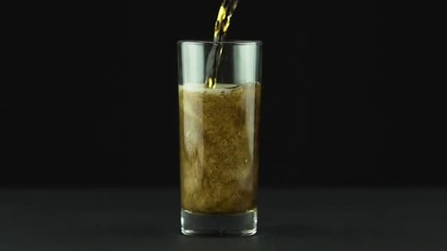 Dark Soda Being Poured into Glass