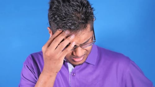Adult Male Rubbing Forehead in Pain