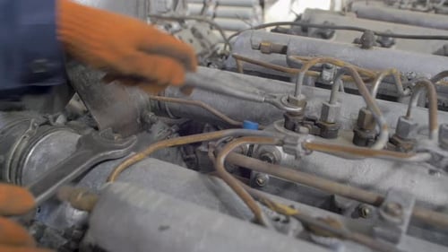 Mechanic Repairing Dirty Engine with Wrench Close Up
