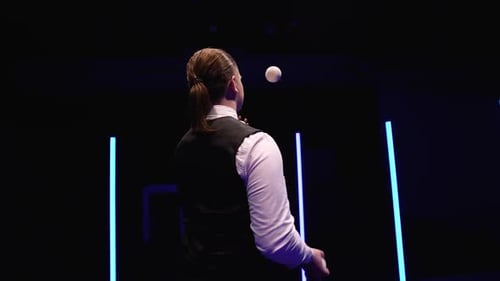 Circle Movement Kamera um professionellen Zirkuskünstler jongliert weiße Bälle gegen ein Schwarz