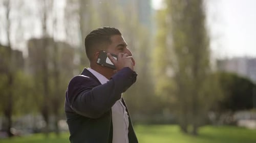 Man Celebrates Good News on Phone in Park