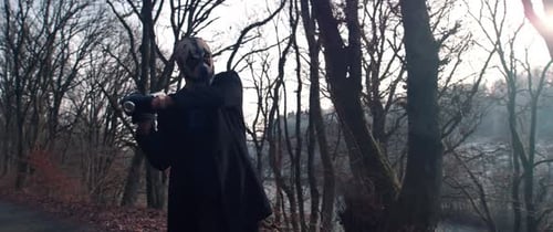 Clown Mask Figure with Bat on Forest Path