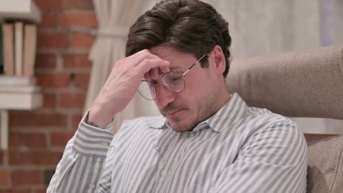 Man Talking Indoors Rubbing Forehead