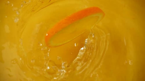 Orange Slice Falling Into Orange Juice