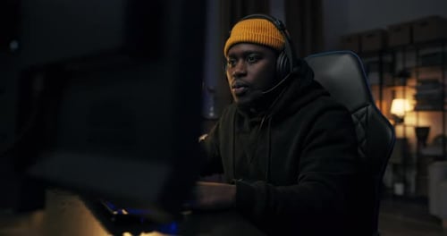 Young Adult Using Computer at Desk at Night