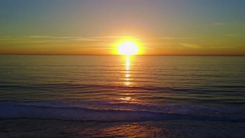 Aerial drone uav view of a sunset over the beach and ocean.