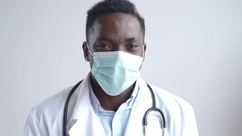 African Black Male Doctor Wears Face Mask Looking at Camera Close Up Portrait