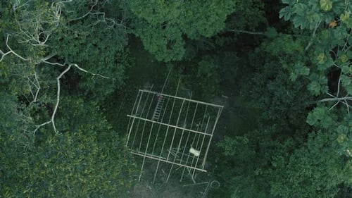 Vista superior de uma pessoa que está trabalhando em uma casa de bambu cercada por árvores