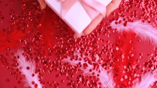 Hands Holding White Gift Box with Pink Ribbon