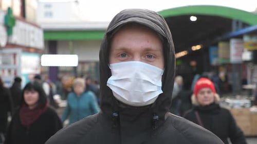 Portrait of Young Man with Medical Face Mask Stands at City Street. Guy Wearing Protective Mask From