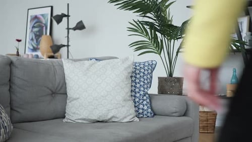 Woman Sits on Gray Couch Indoors