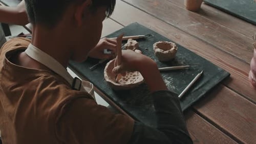 Child Creates Clay Bowl with Art Tools