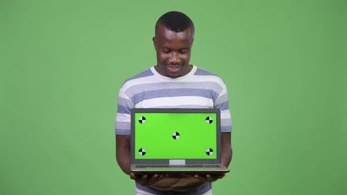 Young Adult Holds Laptop with Green Screen