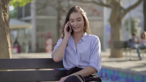 Pretty Caucasian Woman in Park Talking on Phone, Smiling