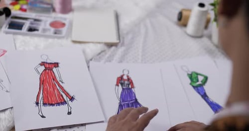 Close up hand of fashion designer man checking a sketch clothing paper