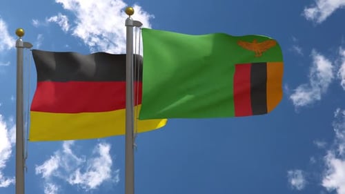 Realistic Waving Flags of Germany and Zambia Against Blue Sky