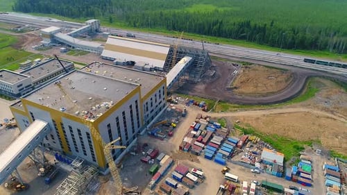 Industrial Building Under Construction on the Background of the Forest.
