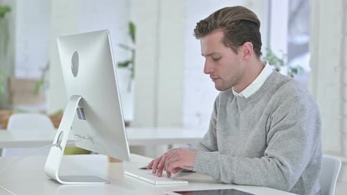 Jeune homme créatif concentré travaillant sur un bureau