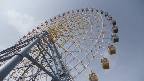 Big Ferris Wheel Rotates at Amusement Park Carnival Ride Over Clean Blue Sky