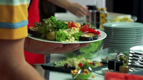 Filling Plate with Salad at a Buffet
