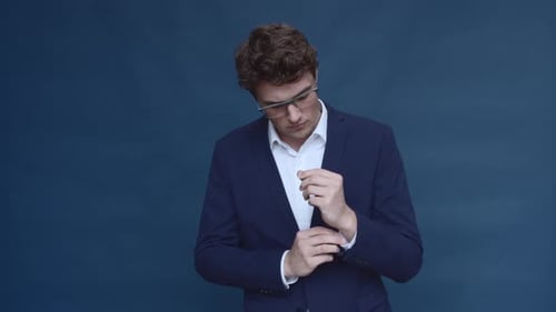 Kaukasisches männliches Model knöpft seinen Anzug zu