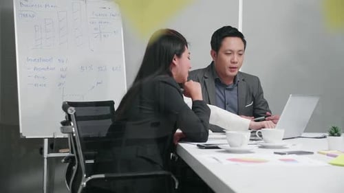 Business Meeting at Table Reviewing Laptop Data