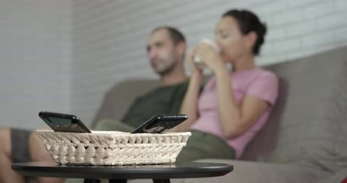 Couple Talking on Couch at Home With Phones