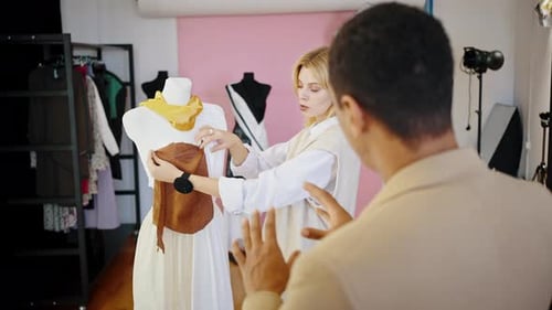 Klient eines afroamerikanischen Mannes im Gespräch mit Schneiderin im Atelier über das Design eines neuen Kleides