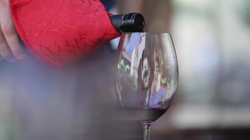 Rotwein. Kellner gießt Wein in Glas in Nahaufnahme des Restaurants